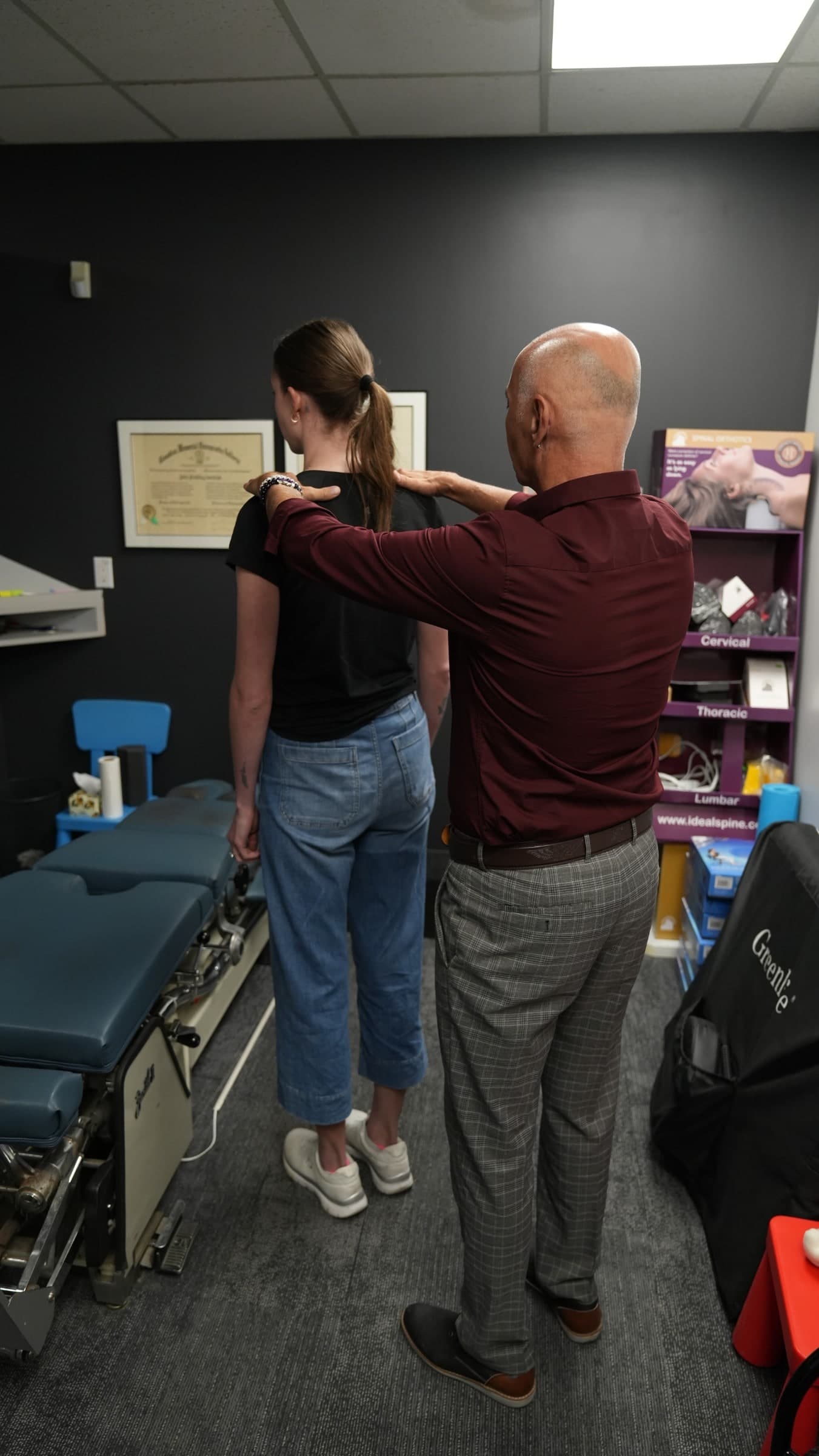 A chiropractor performing a shoulder examination on a patient in a treatment room at Life Chiropractic Centre in Burlington, Ontario